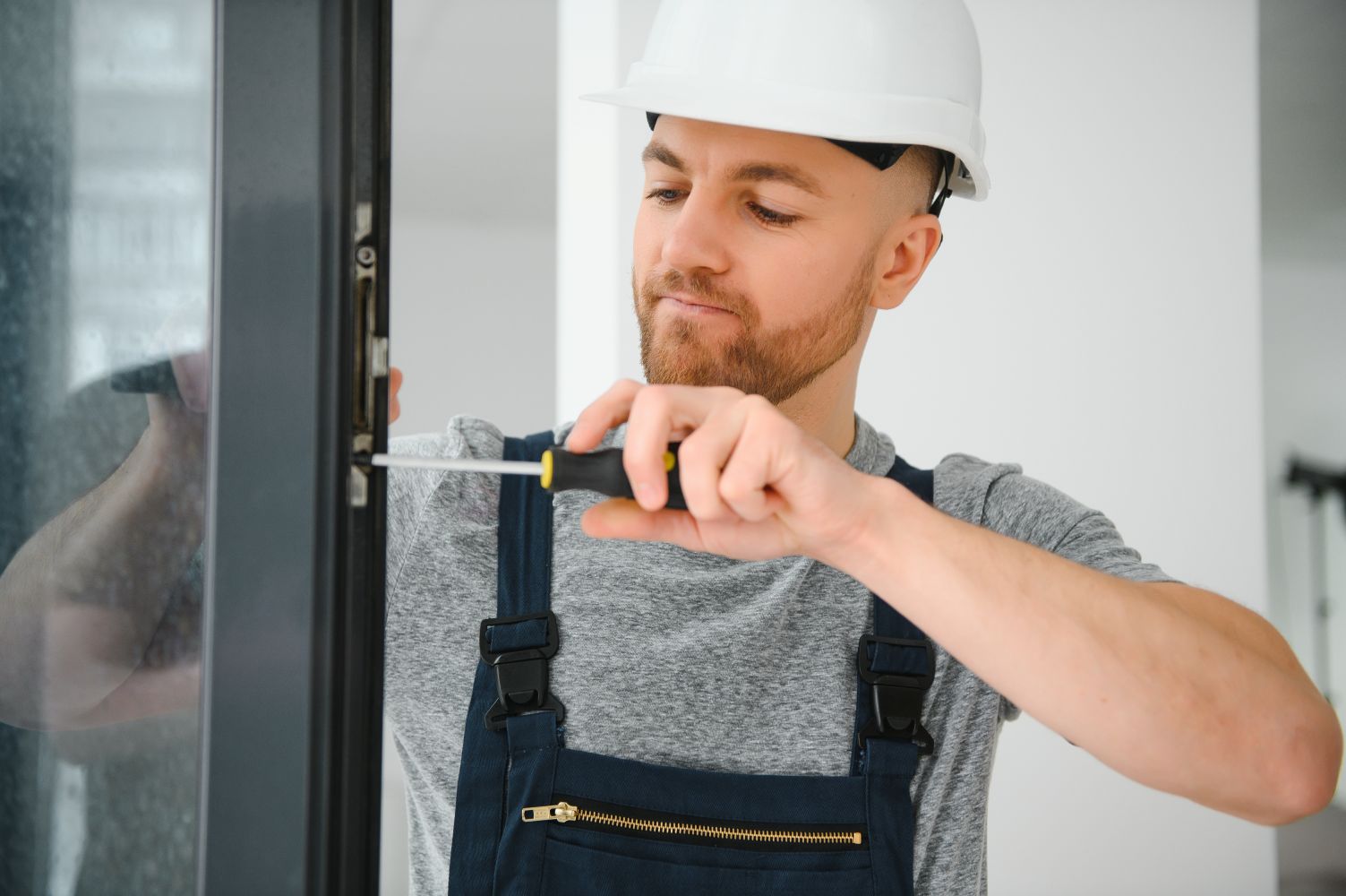 Technicien effectuant une maintenance préventive sur une porte coulissante automatique.